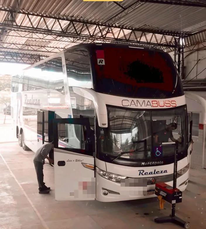 Ônibus rodoviário de dois andares dentro do pátio coberto da SIV, com o selo da ANTT na porta, durante a inspeção técnica