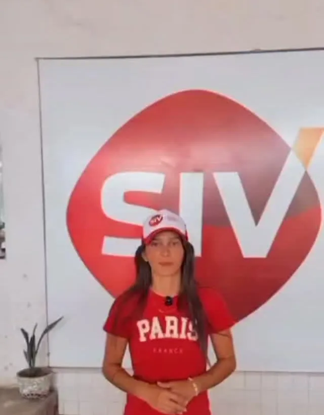 Atendente de boné da SIV em frente ao painel vermelho da marca, na recepção do pátio